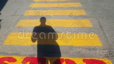 一个人站在行人过路处的开头，在那里停下来，等待经过的时间，在黄色的